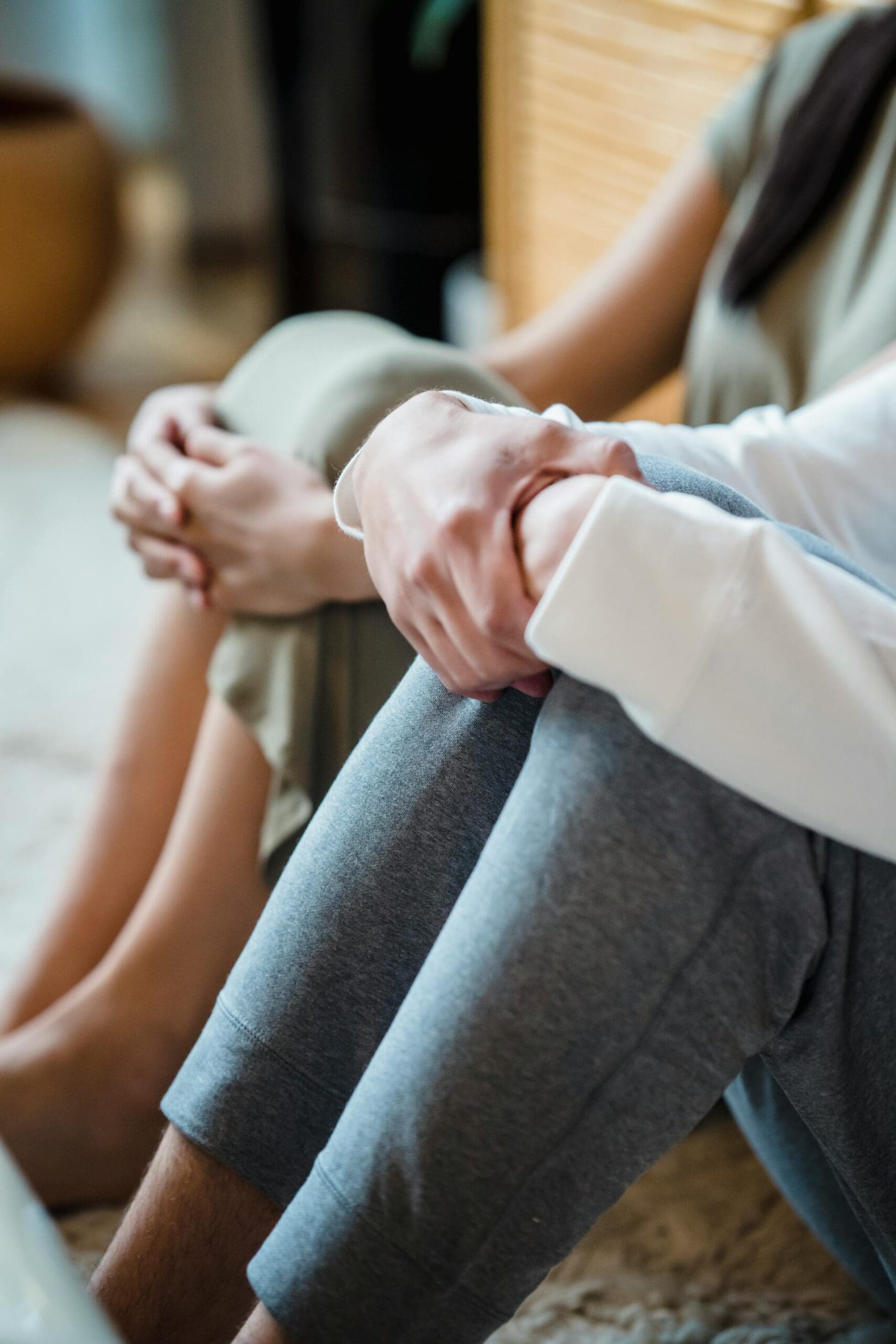 Two people holding their knees with both hands