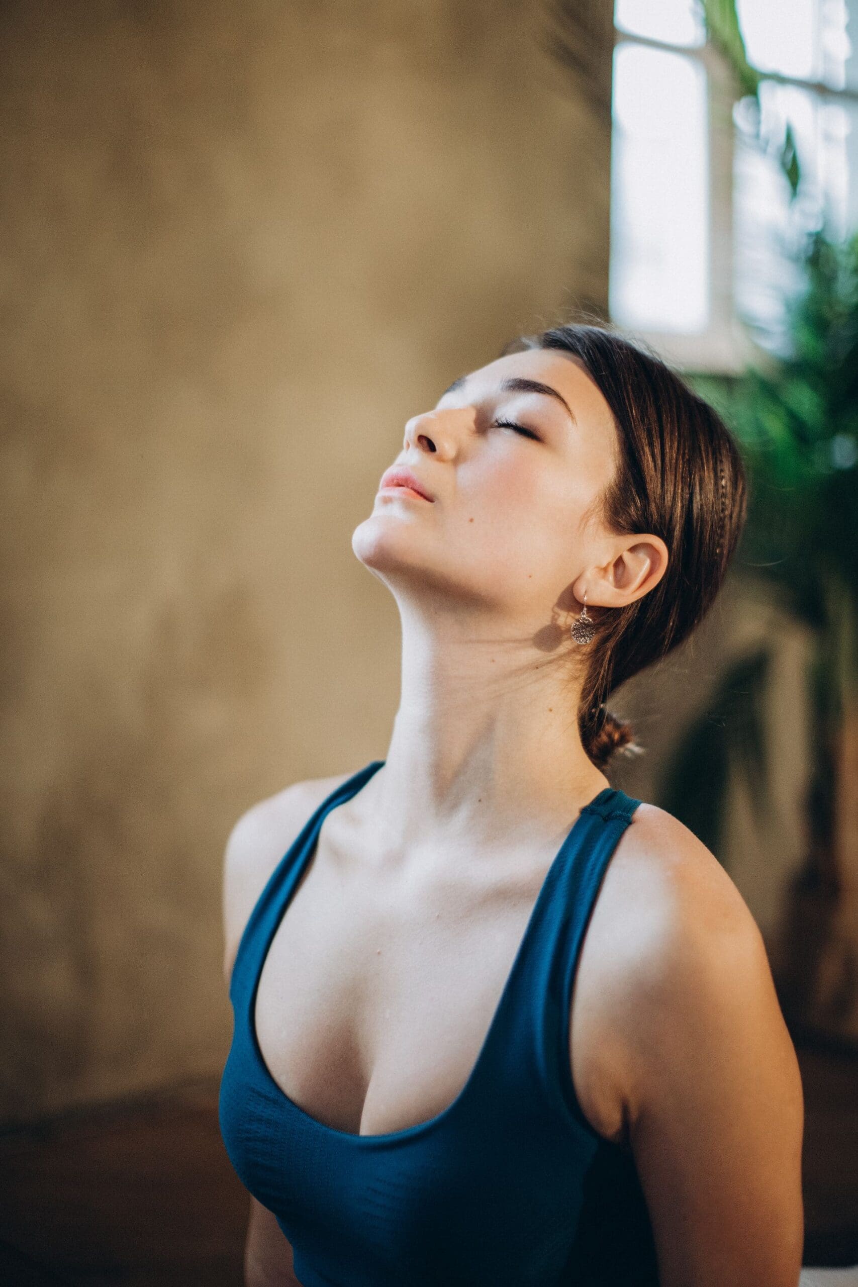 Woman with eyes closed and face tilted toward the light, breathing calmly as she learns to stop numbing her emotions.